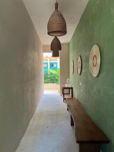 a hallway with a bench and a green wall at T'uut' Hotel in El Cuyo