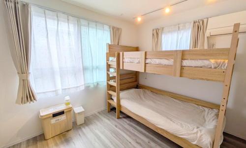 a bedroom with two bunk beds and a window at KamaKama Stay in Tokyo