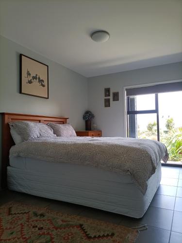 a bedroom with a bed and a large window at Central Diamond Harbour Guest Suite in Diamond Harbour