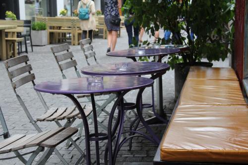 three purple tables and chairs on a patio at Oldtown Hostel Otter in Zürich