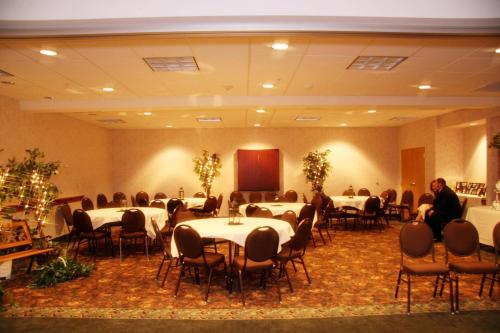 a room with tables and chairs and a man sitting in the middle at Country Inn & Suites by Radisson, Idaho Falls at the Mall in Idaho Falls
