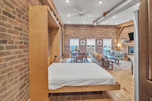 a bed in a room with a brick wall at Moore on Main in Abingdon