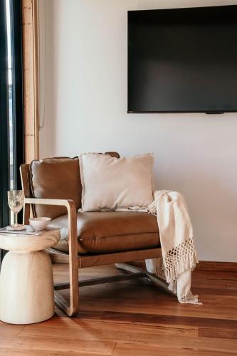 a brown leather couch in a living room with a table at 3 Acres by the Moyne in Port Fairy