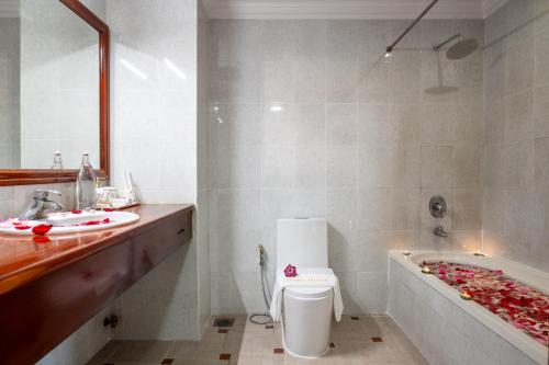 a bathroom with a toilet and a sink and a tub at Domi Hotel in Siem Reap