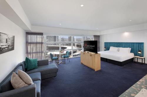 a hotel room with a bed and a couch at Swiss-Belhotel Woolloongabba, Brisbane in Brisbane