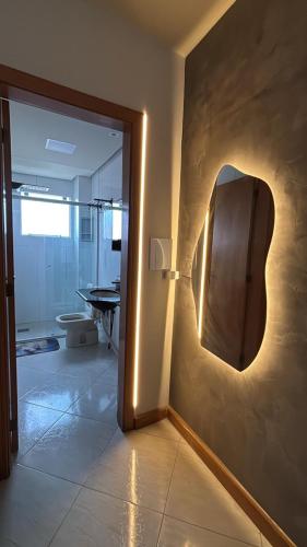 a bathroom with a door with a mirror on the wall at Apartamento no Centro 2 Wi-Fi Garagem in Vacaria