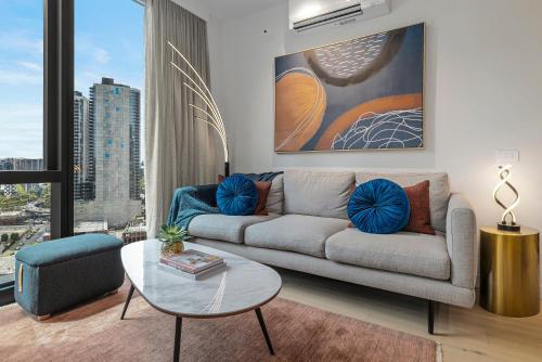 a living room with a couch and a glass table at The Signature Melbourne Modern Nostalgia in Melbourne