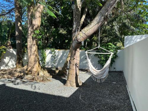 Eine Hängematte hängt an einem Baum neben einem Zaun. in der Unterkunft Villa Bamboo in San Juan