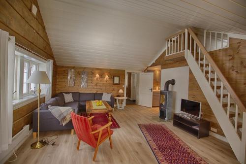 a living room with a couch and a staircase at Modern Comforts, and Ski Access in Beitostøl