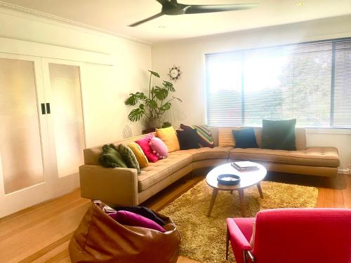 a living room with a couch and a table at Yarra Valley Lifestyle Complete Home in Healesville Accommodates 6 adults Close to wineries Beautifully styled with excellent amenities Walk to town Welcome to No 4 Plenty of parking and outdoor space in Healesville
