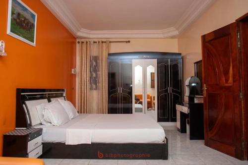 a bedroom with a bed and an orange wall at Cabral residence in Guediawaye