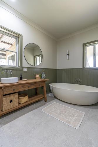a large bathroom with a large tub and a mirror at Mara Luxe Farm Stay 20 mins from Beach in Forster