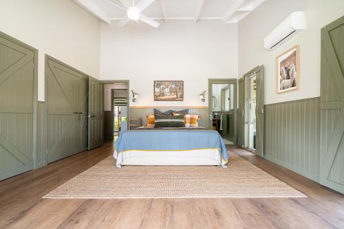a bedroom with a bed with a blue bedspread at Mara Luxe Farm Stay 20 mins from Beach in Forster