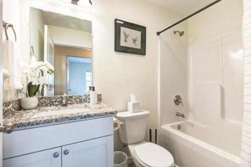 a bathroom with a toilet and a sink and a shower at Stylish New Construction Home in Salina