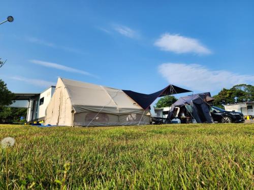 a tent in the middle of a grass field at Seogwipo PyoseonCaravan in Seogwipo