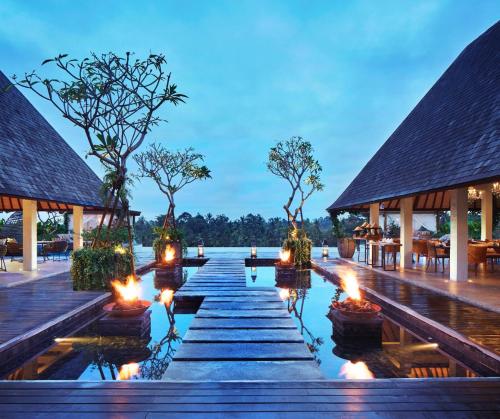 a resort with candles in the water at night at Goya Boutique Resort in Ubud
