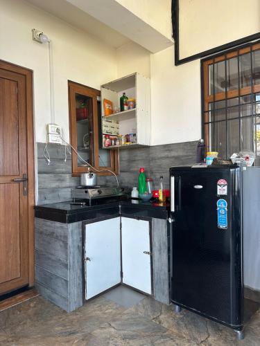 a kitchen with a black and white refrigerator at Bagaan Villa Homestay in Ilām