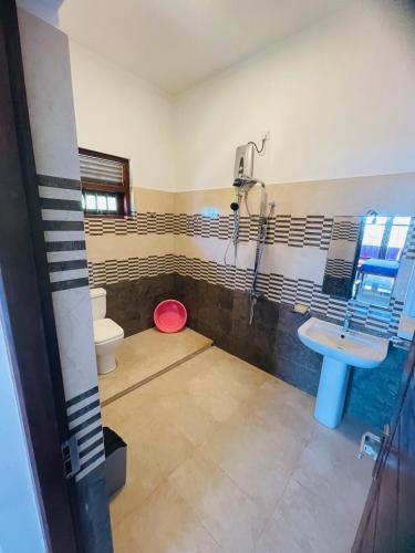 a bathroom with a toilet and a sink at Hotel Meer in Ambalangoda