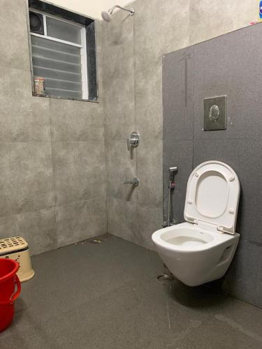 a bathroom with a toilet and a shower at Kimaya Cottage - 2BHK 1 Washroom in Trimbak