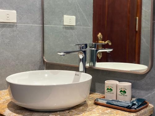 a bathroom with a white sink and a mirror at Tam Coc Vivana Hotel in Ninh Binh