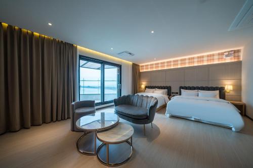 a hotel room with a bed and a table and chairs at Brown Dot Hotel Siheung Geobukseom in Siheung