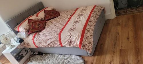 a bed with red and white blankets and pillows at Beautiful home feeling No 62 in Croydon