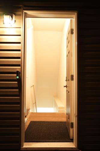 an open door to a hallway with a stair case at Cozzy Cityscape & Airport Retreat in Calgary