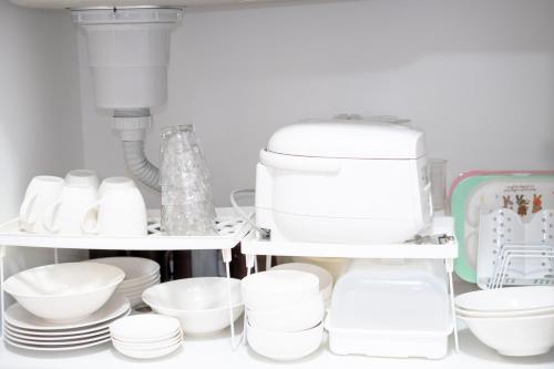 a kitchen shelf with dishes and a coffee maker at 高松の宿晴れとケ in Takamatsu