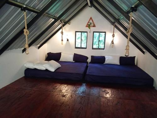 a room with a large blue bed in a attic at Downtown Lodge in Nuwara Eliya