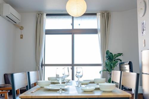 a dining room table with chairs and a large window at 高松の宿晴れとケ in Takamatsu