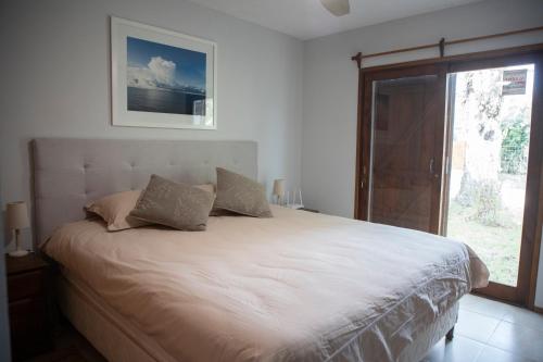 a bedroom with a large white bed with a window at Casa Nopal in Punta del Este