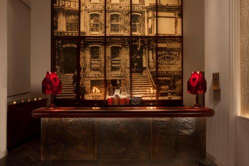 a wall with two red flowers on a table at The Redbury New York in New York
