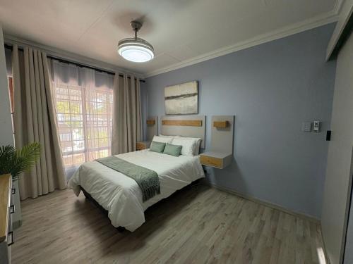 a bedroom with a bed and a large window at The Marley in Polokwane