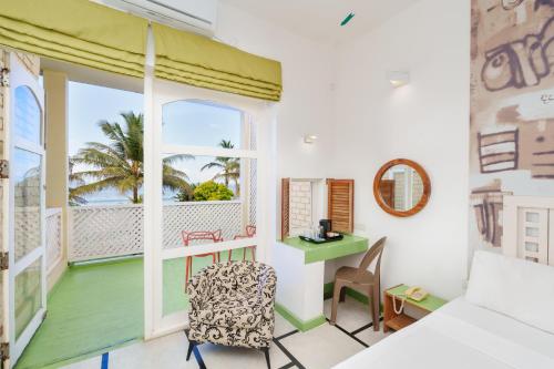 a room with a bed and a desk and a window at Hotel J Negombo in Negombo
