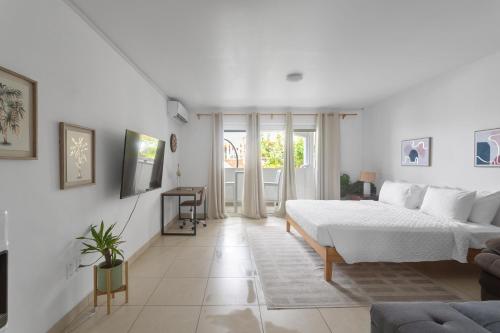 a white bedroom with a bed and a couch at Maho Beach House - Studio - Beach Access in Maho Reef