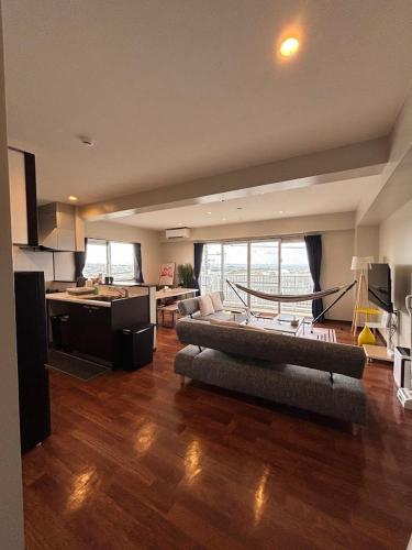 a large living room with a couch and a kitchen at The Villa Lino in Yomitan