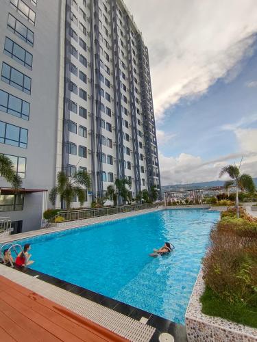 a swimming pool in front of a large building at Arc Tower Cebu 1714 in Cebu City