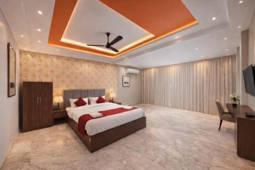 a bedroom with a bed and a desk in a room at Hotel R-A-M-A-N-S-H GRAND INN - Beside Ram Mandir Ayodhya 96,7000,2101 in Ayodhya