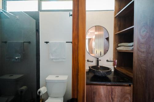 a bathroom with a toilet and a sink and a mirror at Casa Tutuli in Coajomulco