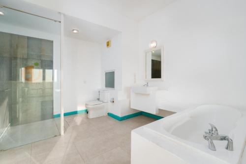 a bathroom with a tub and a sink and a toilet at Hotel J Negombo in Negombo