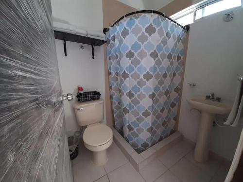 a bathroom with a toilet and a shower curtain at Nice apartment in the north in Hermosillo