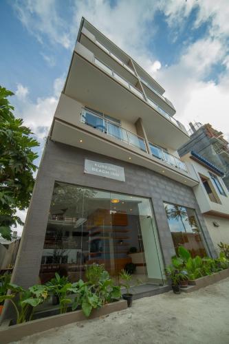 a tall building with a store front with plants at Kuredhi Beach Inn in Maafushi