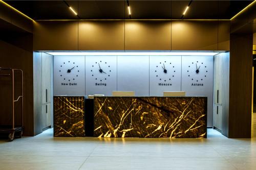 a room with a counter with three clocks on the wall at Mildom Residence in Almaty