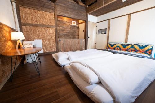ein Schlafzimmer mit einem großen weißen Bett und einem Tisch in der Unterkunft ゆらゆら亭 Yura Yura Tei Niseko in Rankoshi