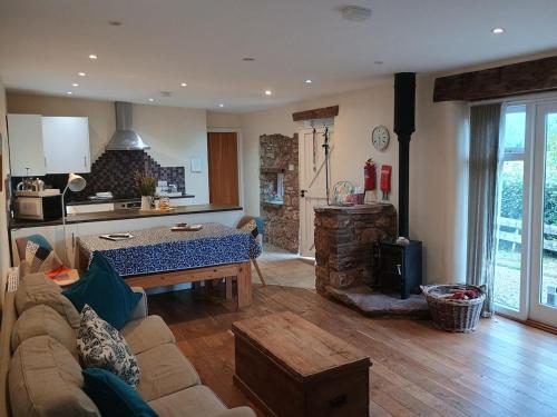 a living room with a couch and a table in a kitchen at Long Barn Wales in Monmouth