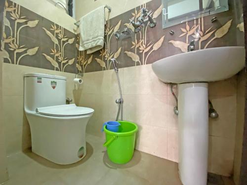 a bathroom with a toilet and a sink at Hotel Maheshwor in Pashupatināth