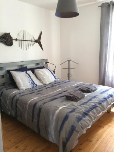 een slaapkamer met een bed met een vis aan de muur bij Proche plage et marché, grand jardin, barbecue 9 pers in La Baule