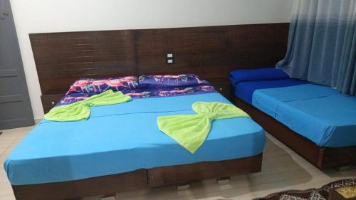 two beds in a room with blue sheets at ABAZIDO Nubian Guest House in Aswan
