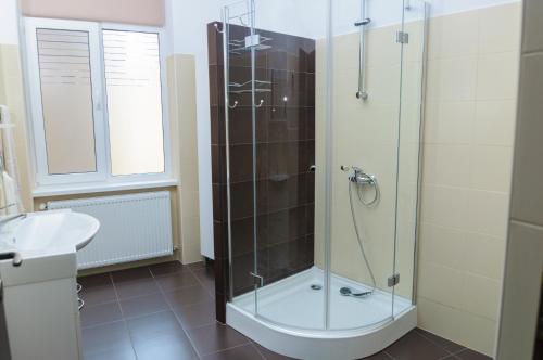 een badkamer met een glazen douche met wastafel bij Lorena Apart Old Town in Boekarest