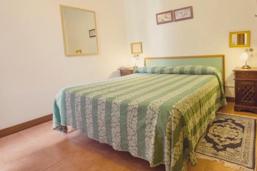 a bedroom with a bed with a green comforter at Hotel Centrale in Viterbo
